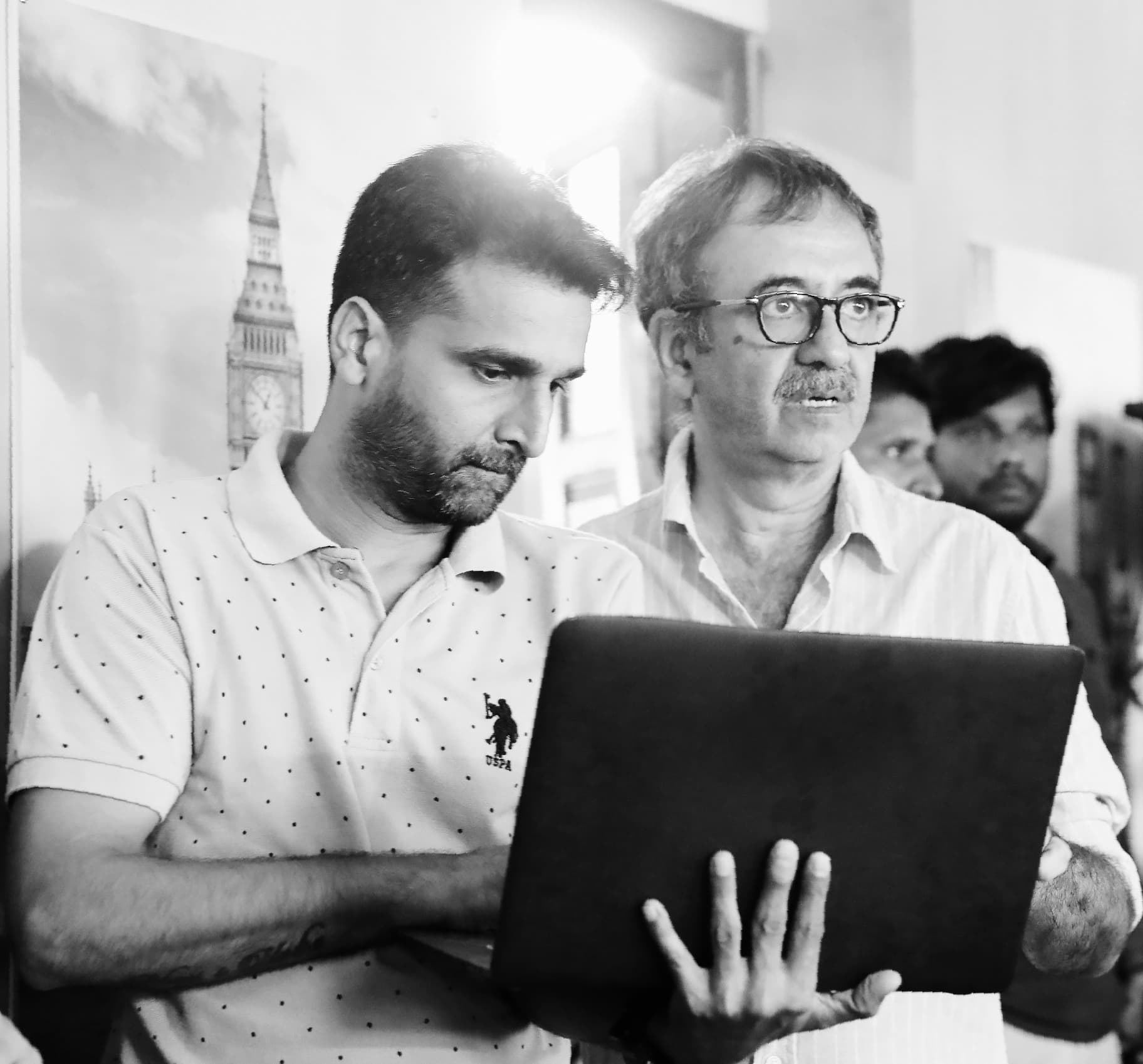 Behind-the-scenes: Hitesh reviewing footage with director on laptop during post-production