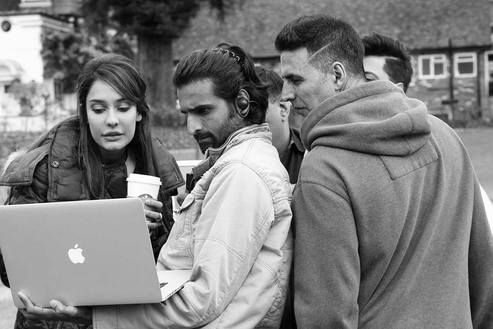 Location shoot: DIT work with cast and crew reviewing footage outdoors